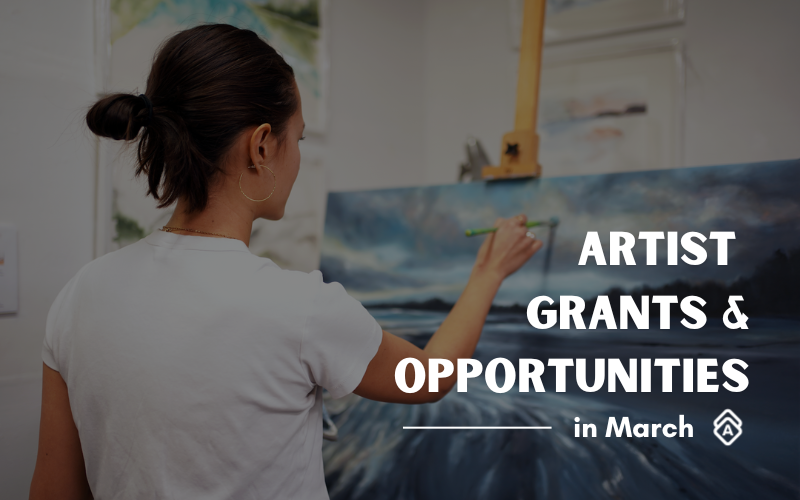 Alt text: A promotional image for "Artist Grants & Opportunities in March" featuring artist Tiffany Blaise in a white t-shirt painting on a canvas mounted on an easel. The artist is shown from behind, working on what appears to be a seascape or ocean scene. The background shows other artwork on white walls. The text is overlaid in white capital letters on the right side of the image, creating a professional and inviting composition for artists seeking funding opportunities.