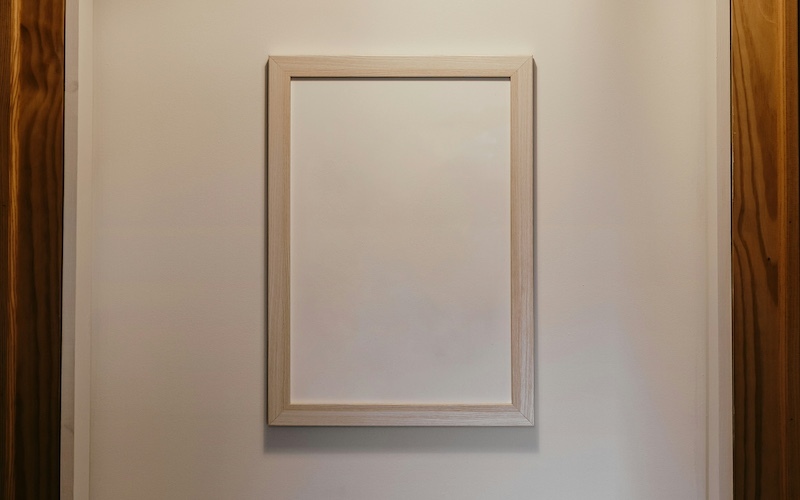 An empty frame on a white wall