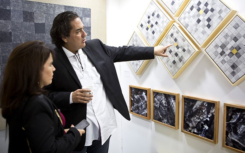 An artist speaking with a woman about his artwork