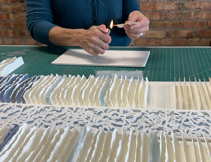 An artist burning a piece of paper