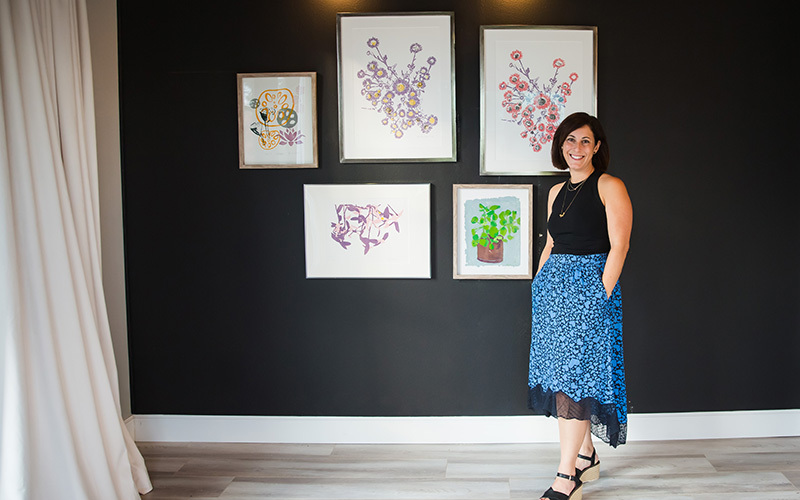 An artist in front of her prints