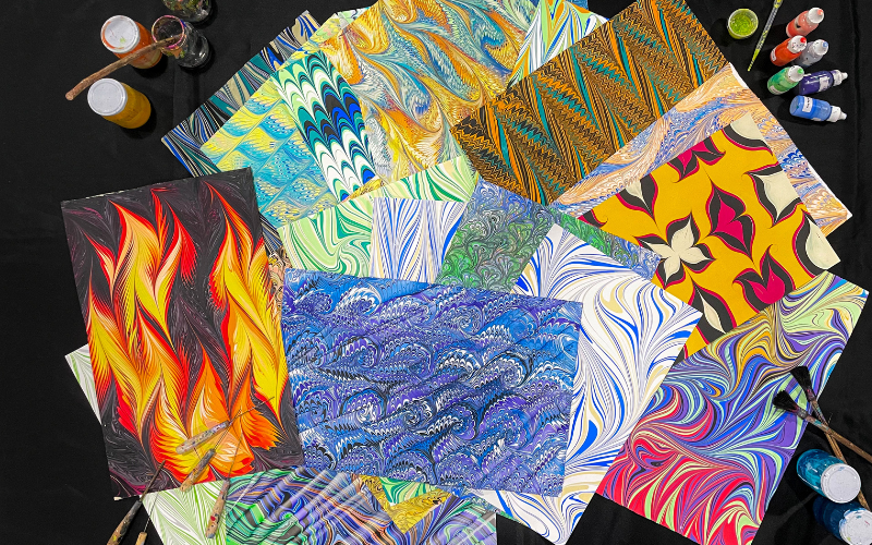A spread of Keith Garubba's marbled paper works, each one a one-of-a-kind result of paint on water — no two ever quite the same. Photo courtesy of the artist.