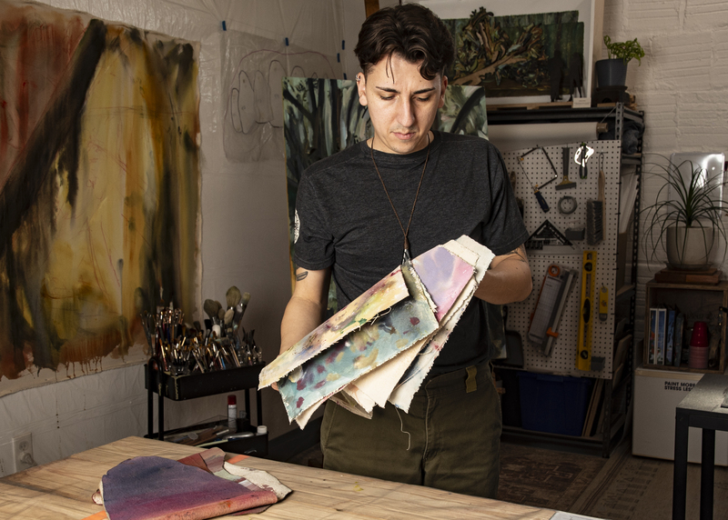 An artist sorting artworks in his studio