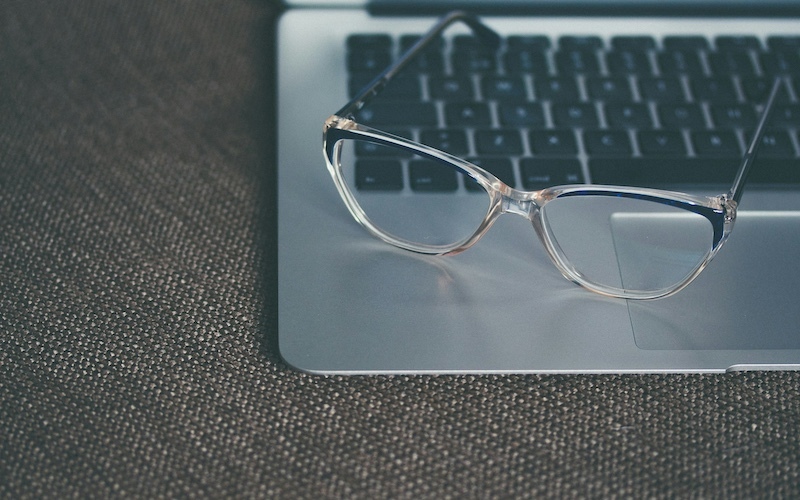 Pair of glasses resting on a computer keyboard