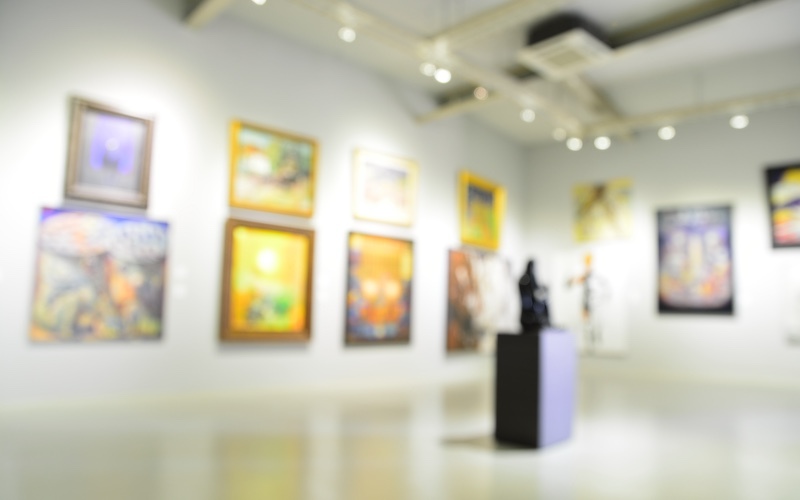 Blurry out of focus photo of an art gallery with framed art on the walls