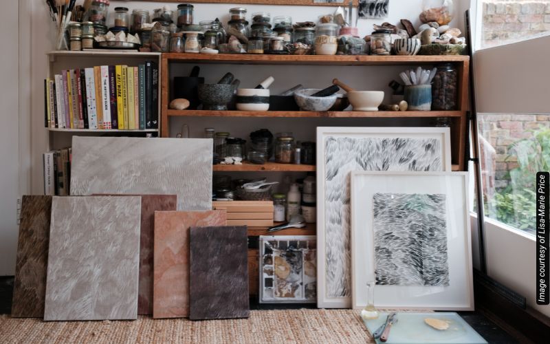 An artist's studio with canvases leaning against a bookshelf